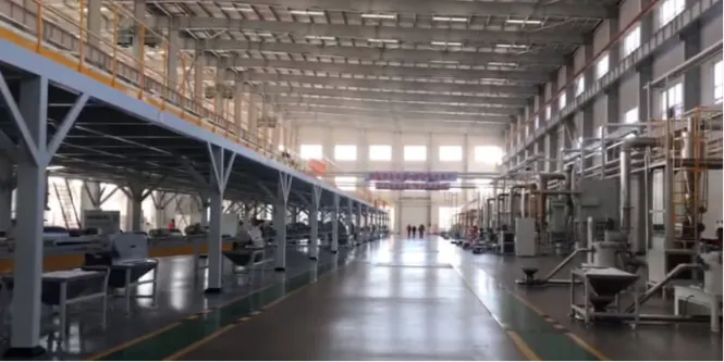 Vue intérieure d'une ligne de production de revêtement en poudre industrielle avec des machines de mélange, d'extrusion et de broyage à grande échelle dans une usine moderne